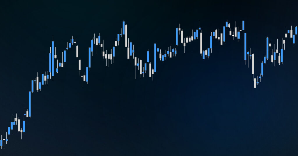 An image of candle charts shown on a tablet and screen.